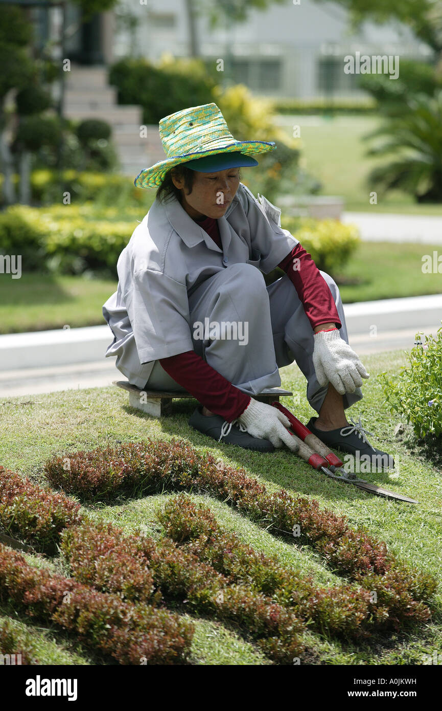 Una signora rivestimenti giardiniere il prato con un set di cesoie in Dusit Park Bangkok in Thailandia Foto Stock