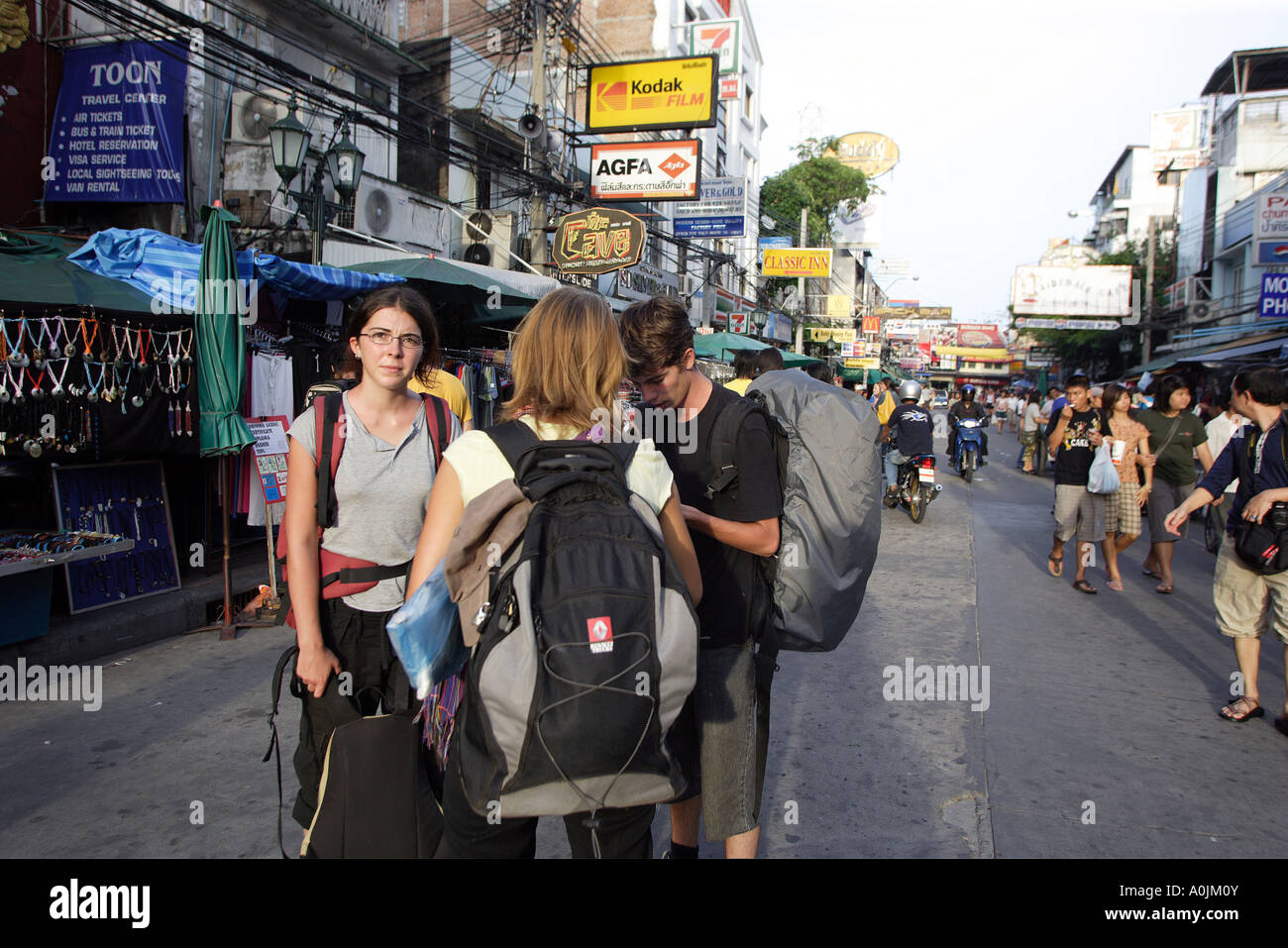 Khao San Road di Bangkok in Thailandia attrae turisti soprattutto backpackers provenienti da tutto il mondo un gruppo di viaggiatori con lo zaino in spalla discutere la loro prossima mossa Foto Stock