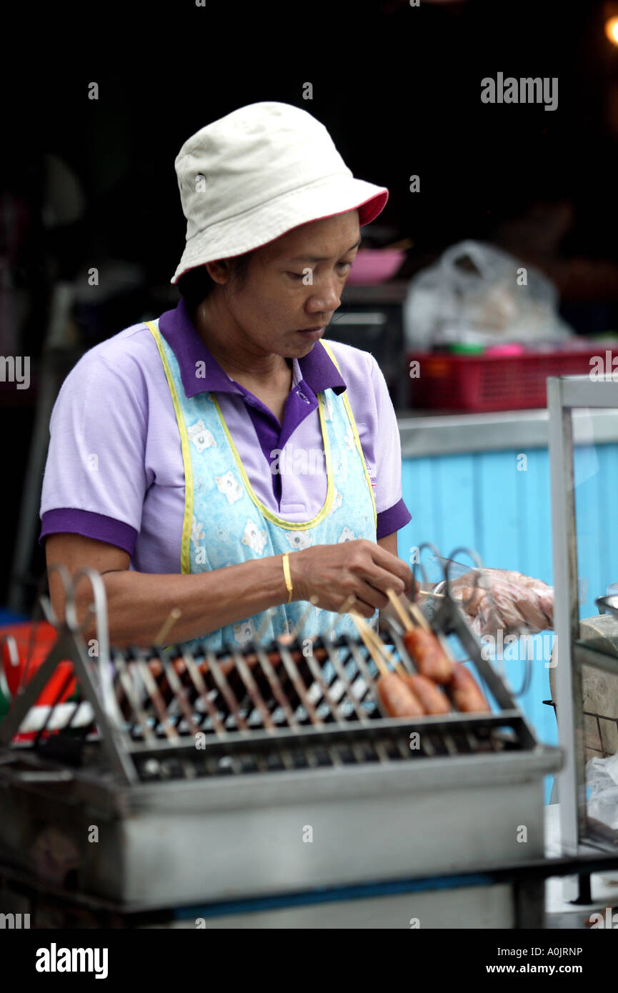 Una signora per la cottura e la vendita di cibo sul canal Klong Bangkok Noi a Bangkok in Tailandia Foto Stock
