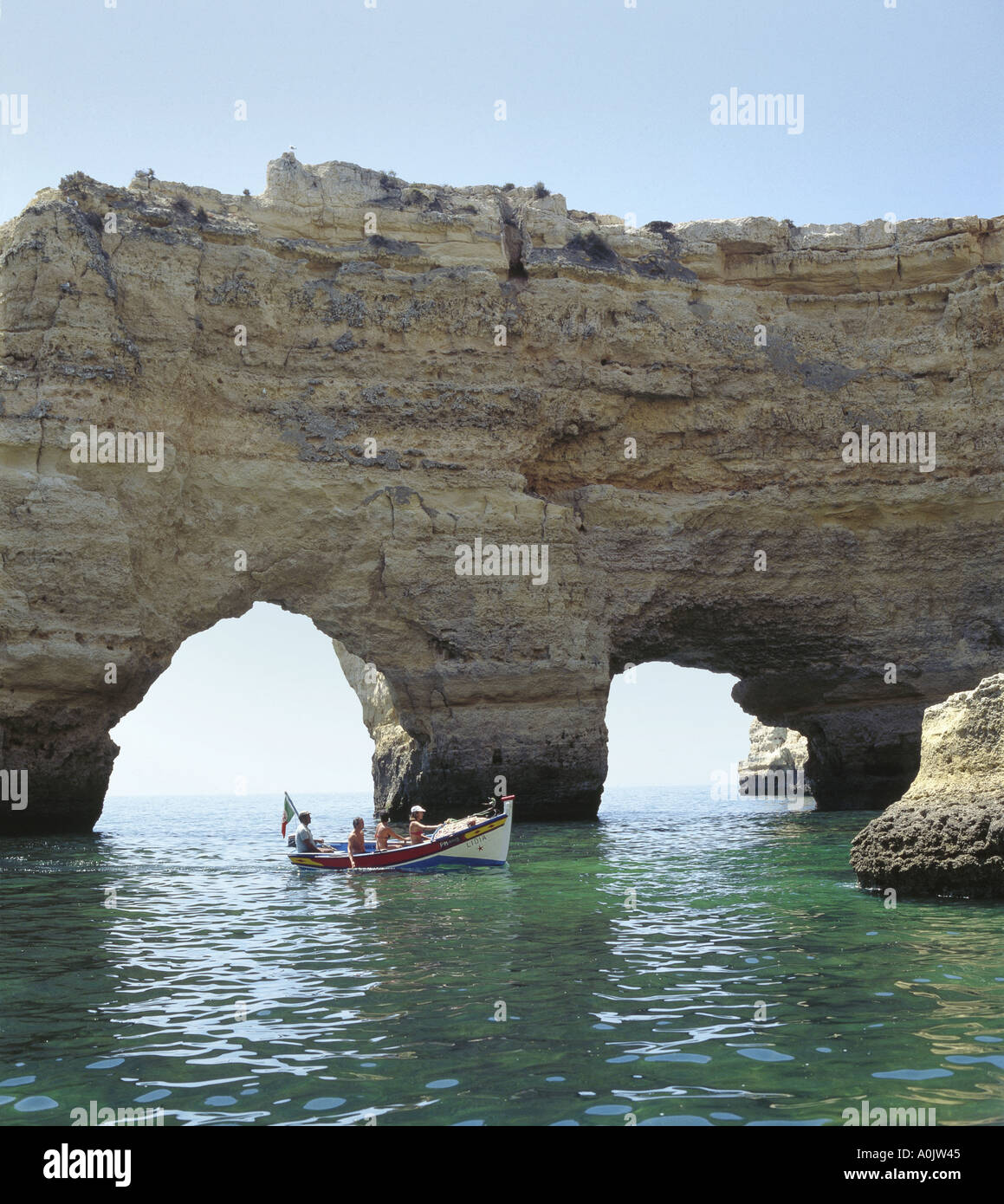 Il Portogallo Algarve, i turisti ad esplorare le grotte e scogliere, vicino a Armacao de Pera escursione in barca da pesca Foto Stock