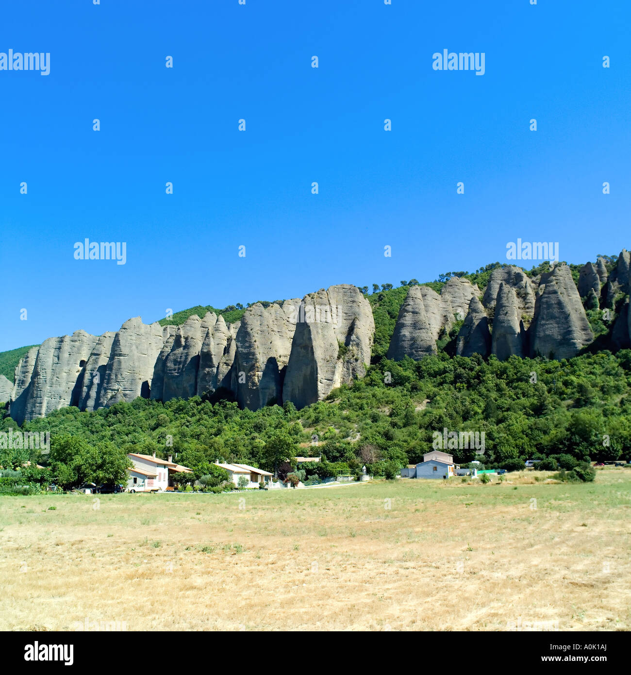 Les Pénitents des Mées formazione di roccia, scogliere, case, Les Mées, valle della Durance, Alpes-de-Haute-Provence, Francia Foto Stock
