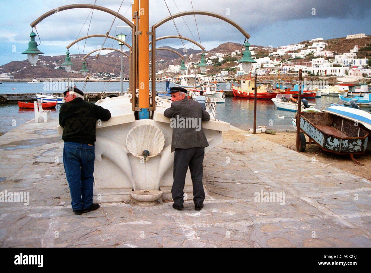 Due uomini guardare a sinistra in unisono, Porto, Hora, Mykonos Grecia Foto Stock