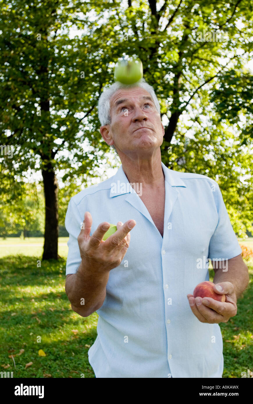 Uomo maturo la giocoleria con frutta Foto Stock