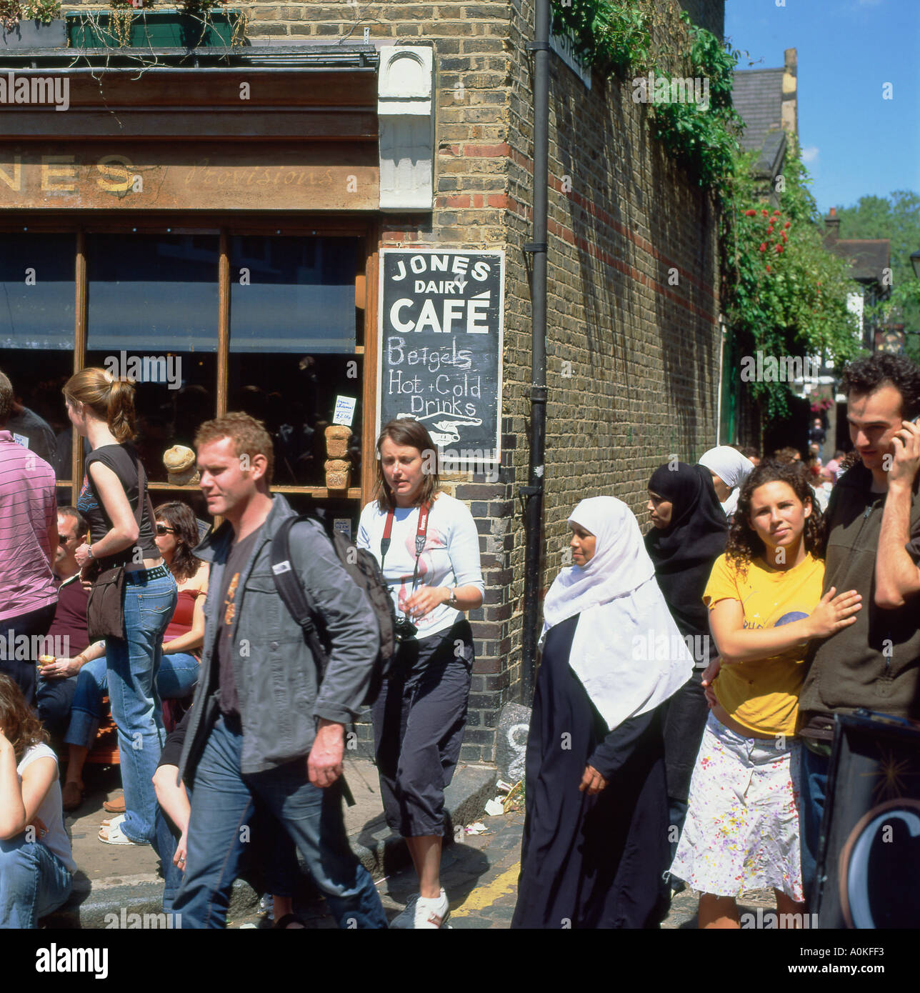 Un occupato domenica mattina con la folla multiculturale di persone camminare davanti a un caffè a Columbia Road Flower Market in Shoreditch East London REGNO UNITO KATHY DEWITT Foto Stock