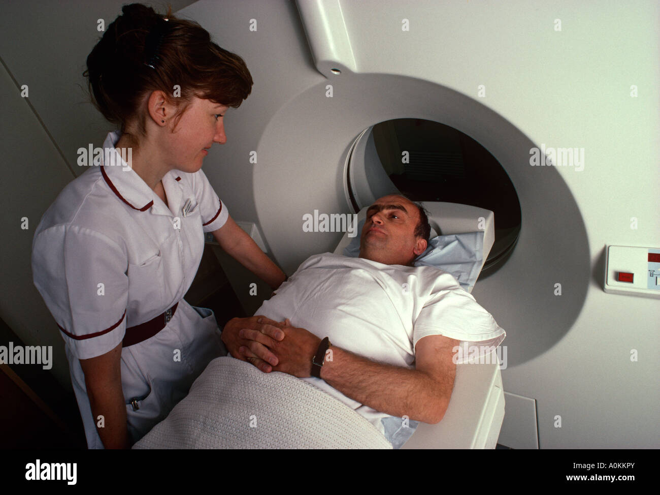 I colloqui di infermiere paziente inserendo uno scanner MRI in un ospedale di Londra, Regno Unito Foto Stock