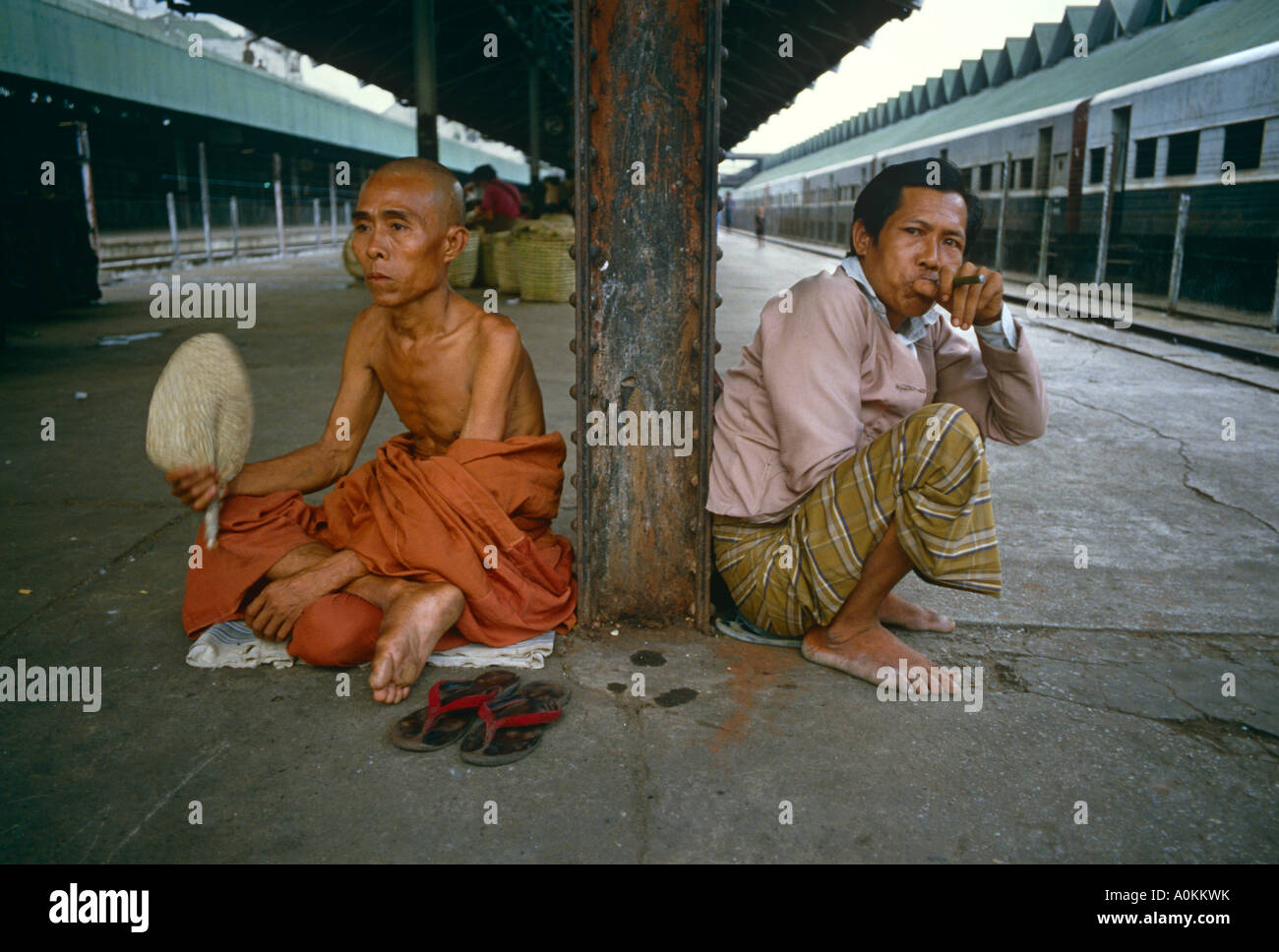 I passeggeri in attesa su piattaforma per un treno alla stazione di Rangoon Yangon Birmania Myanamar Foto Stock