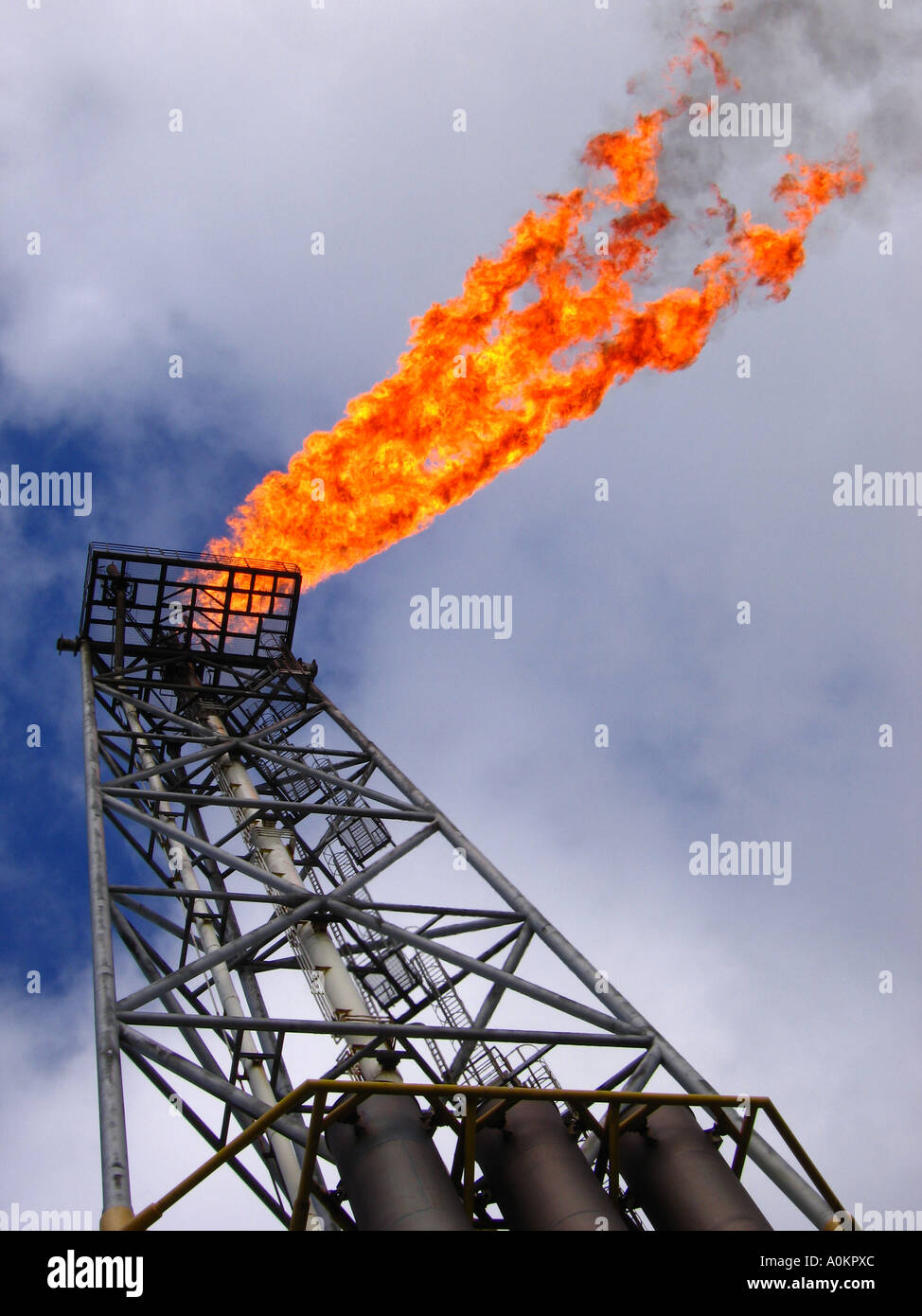 Piena vista del telaio di un illuminato di gas offshore flare e colonna. Foto Stock