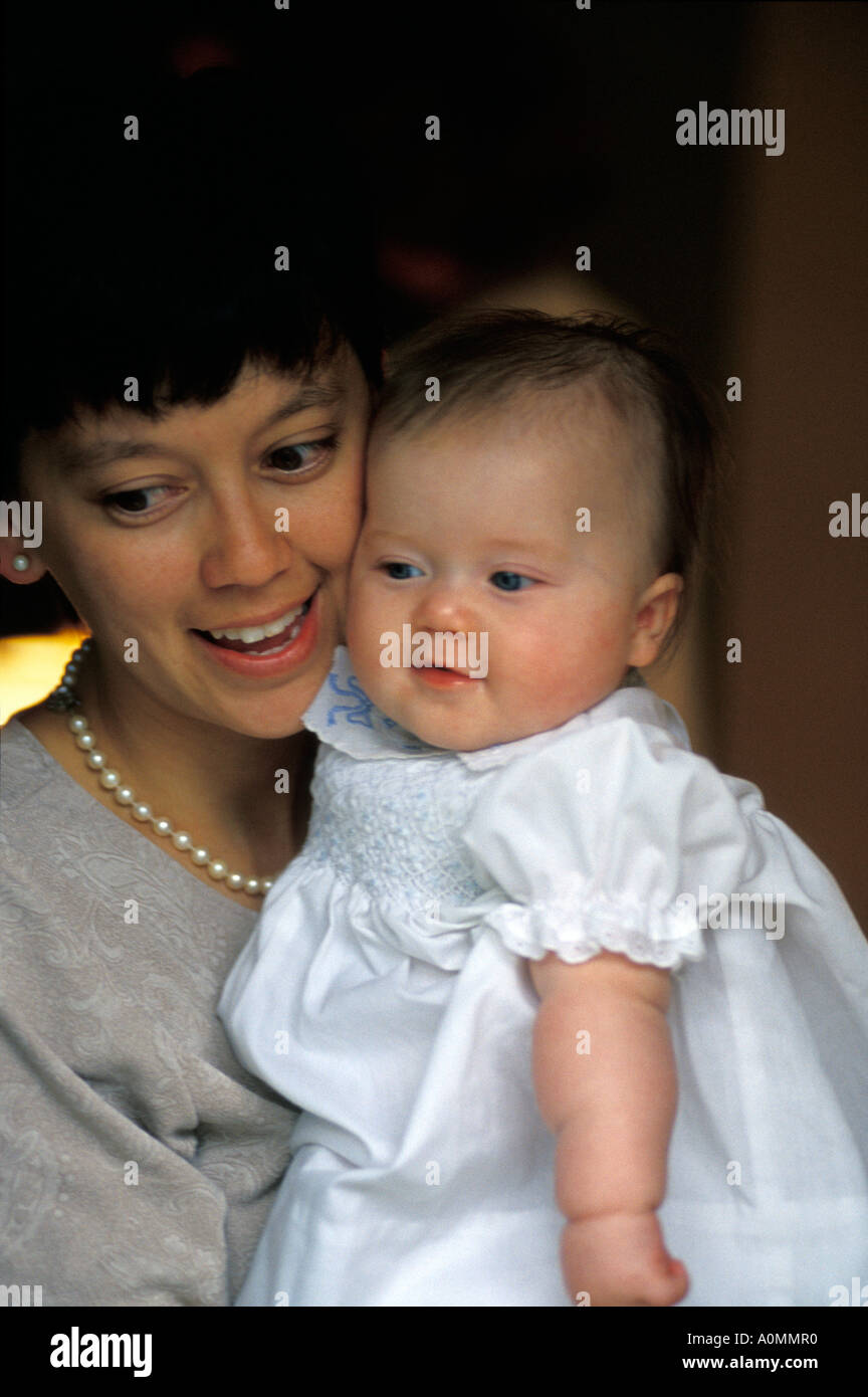 Madre figlia bianco abito battesimo chiesa religione sorriso sorridendo felice gioia spazio copia Foto Stock