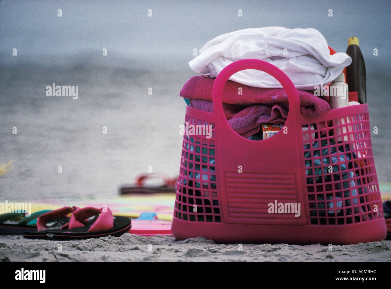 Borsa da spiaggia asciugamano necessità accessori sandali lozione solare borsa rosa spazio copia Foto Stock