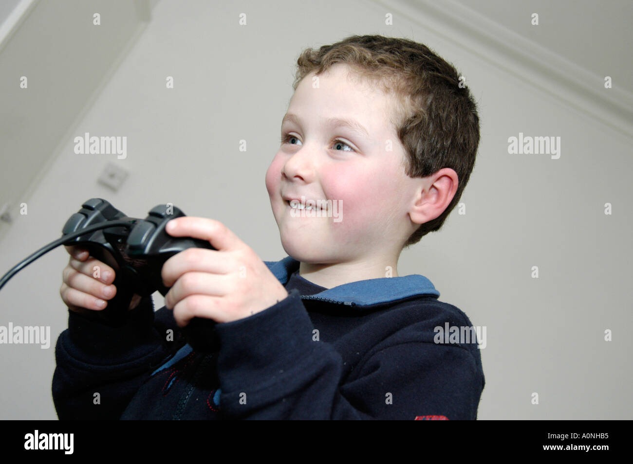 Piccolo ragazzo di 6 Riproduzione di giochi per computer su Sony Playstation console, England, Regno Unito Foto Stock