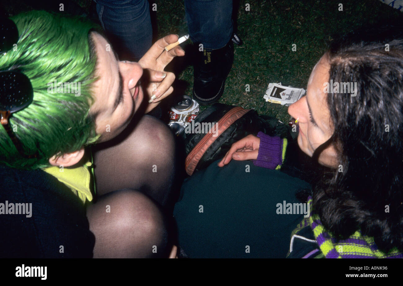 Londra, Inghilterra. Le giovani donne da sopra, uno con i capelli verdi uno con anello di naso, scarpe con suole che rimbalza, Stella Artois luci Marlborough schiacciato. Foto Stock