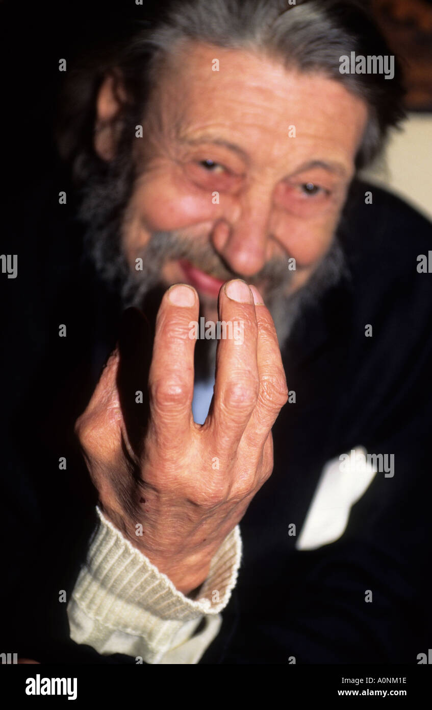 Praga, Repubblica Ceca. Sorridente anziani uomo barbuto con le sue dita artritiche davanti al suo volto. Foto Stock