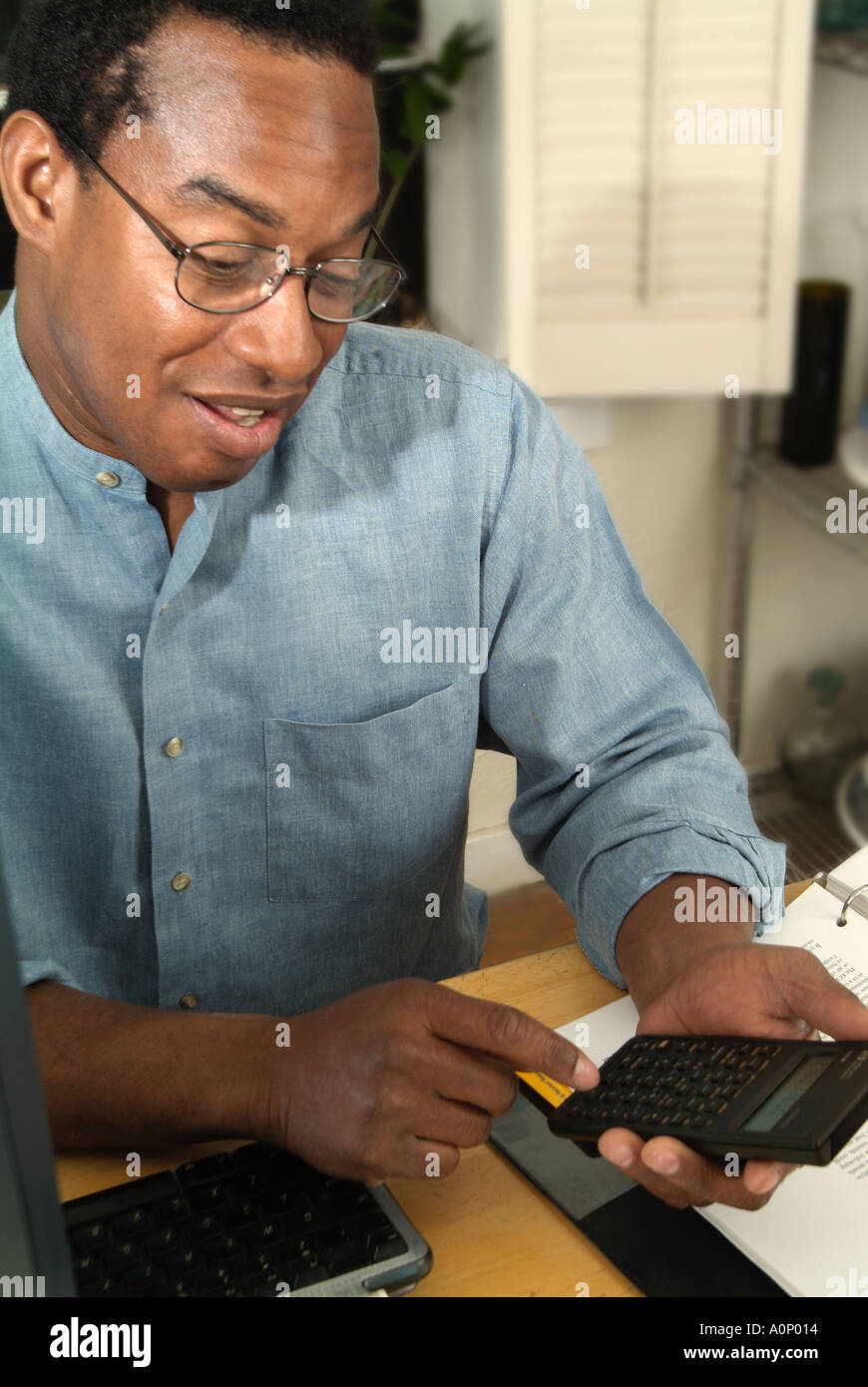 Uomo con la calcolatrice e sorridente Foto Stock