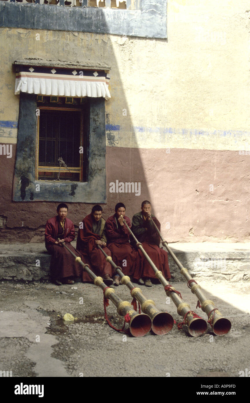 I monaci soffiando la loro tradizionale e lungo le corna in un monastero del Tibet Foto Stock