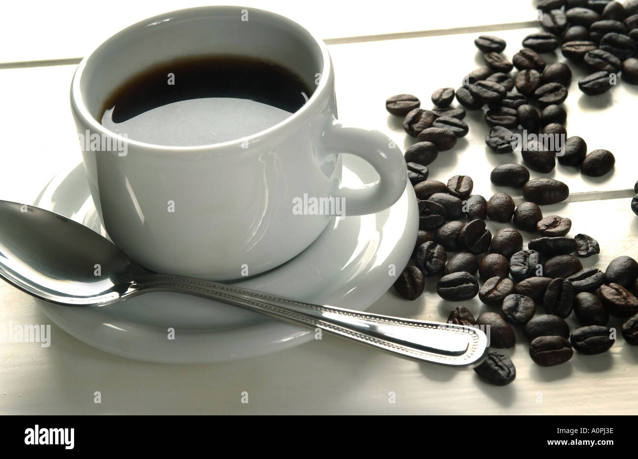 Una tazza di caffè con un mucchio di chicchi di caffè Foto Stock
