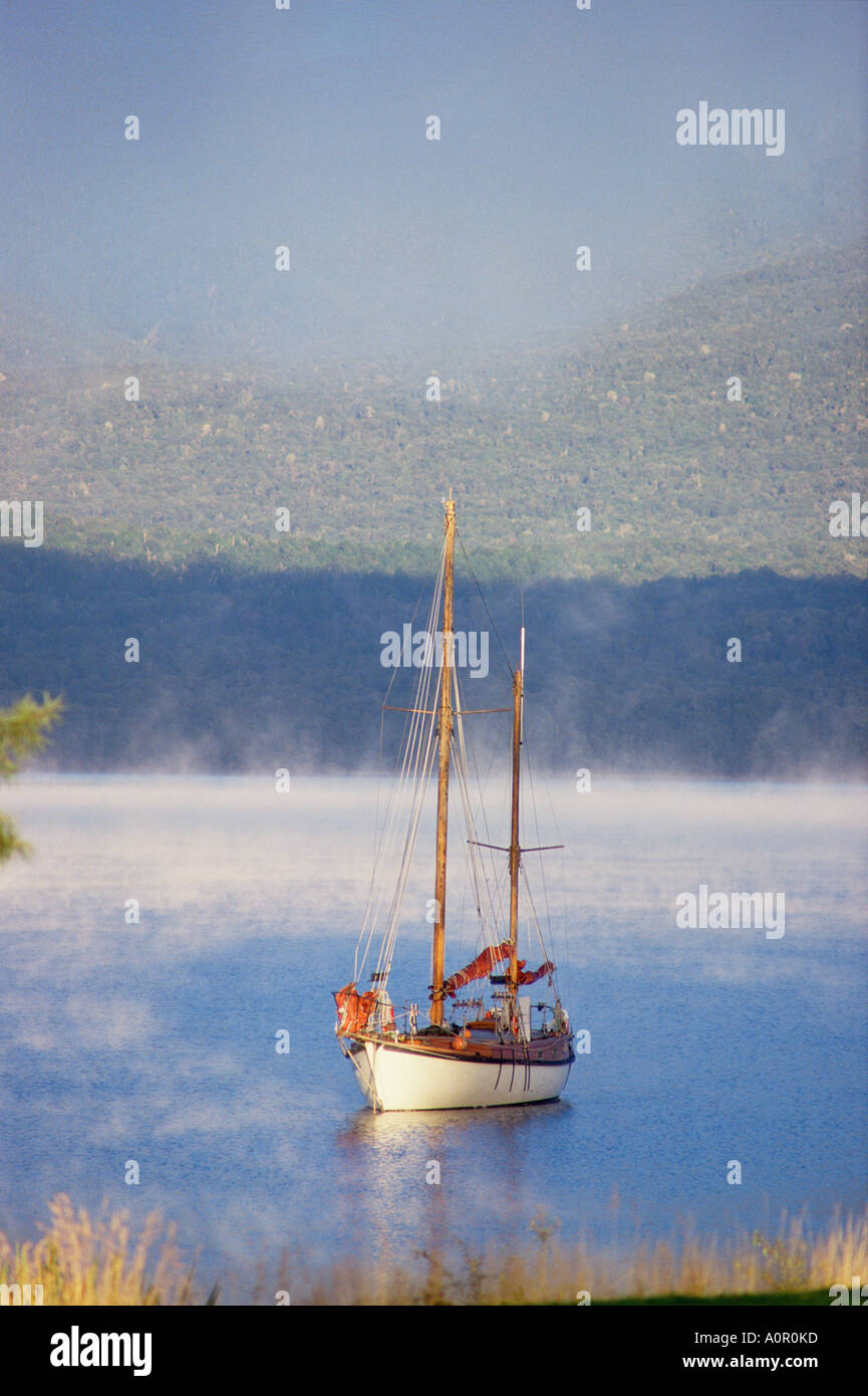 La Nuova Zelanda. Il Lago Te Anau. Lone barca ancorata nella baia. Foto Stock