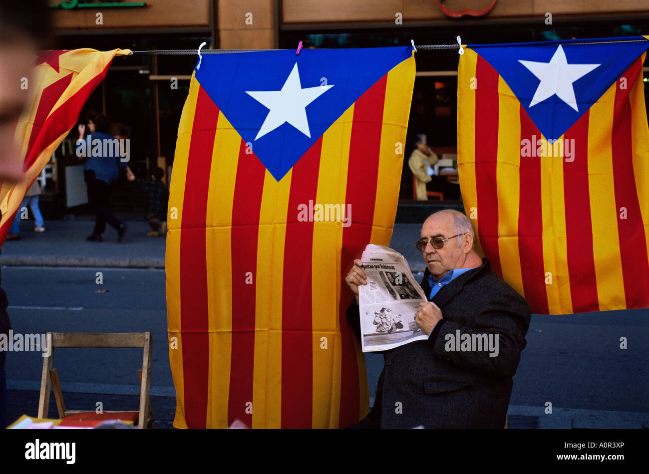 Leggendo il giornale sotto la bandiera della Catalogna sul Rambla Barcellona Catalonia Spagna Europa Foto Stock