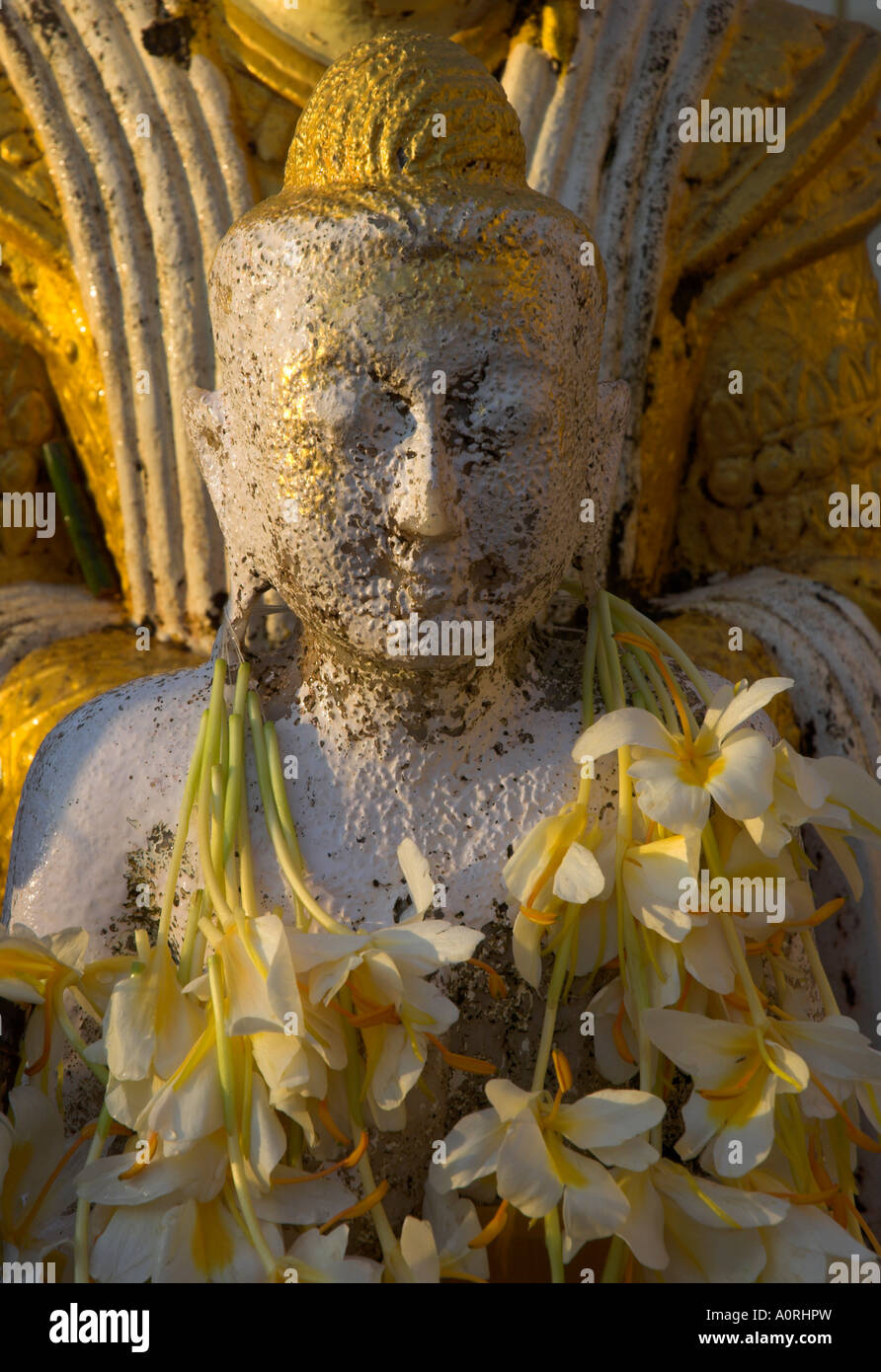 Chiusura del piccolo Buddha figura con fiori intorno al collo nella Shwedagon Paya a Yangon Rangoon MYANMAR Birmania Asia Foto Stock