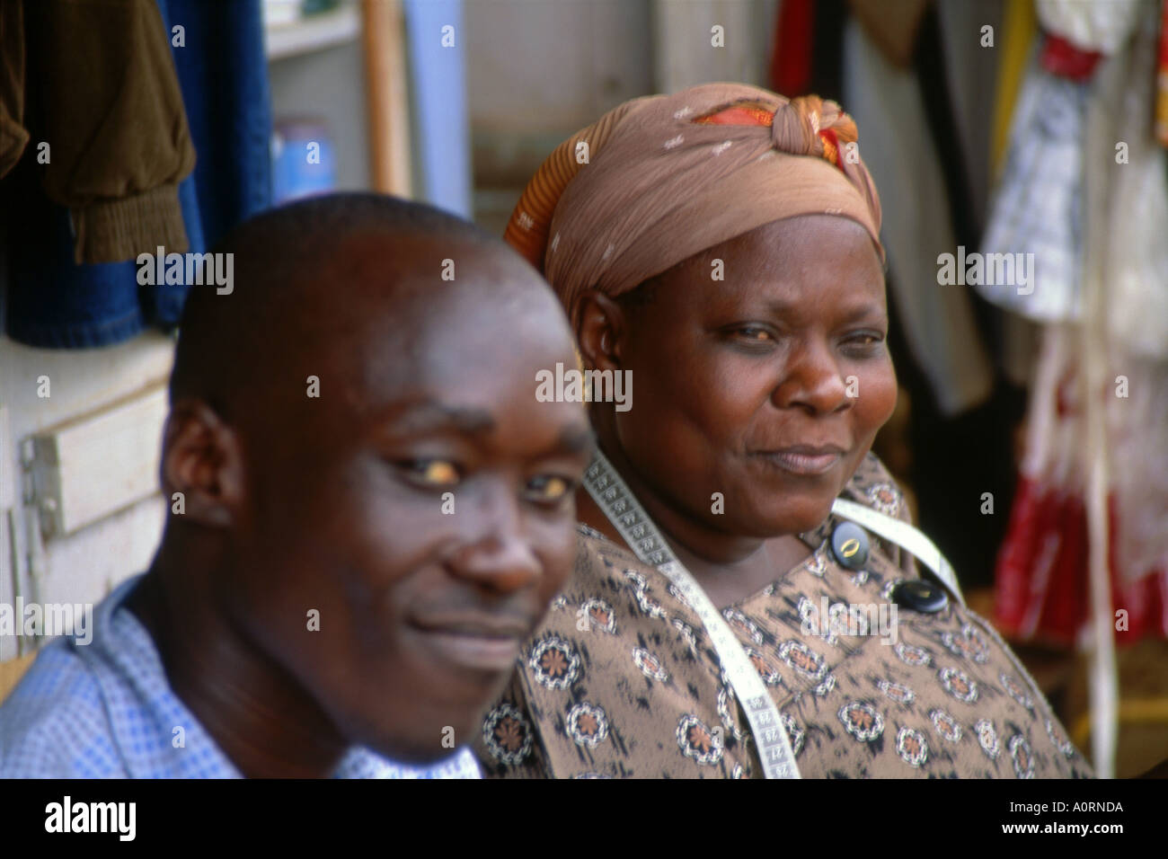 Ritratto di Africano nero street sarto donna e giovane uomo che pongono insieme nella posizione esterna del Jinja Città Uganda Africa orientale Foto Stock