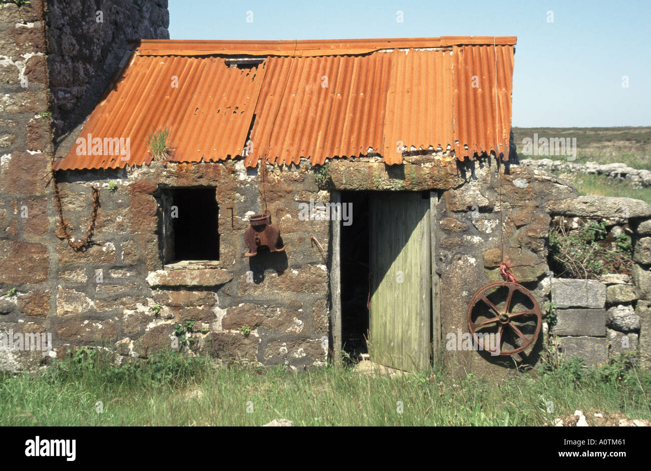 Decadendo rosso ruggine corrugato ferro lenzuola sul tetto di vecchia pietra fatiscente costruito fattoria fuori-costruzione Morvah Cornwall Inghilterra Regno Unito Foto Stock