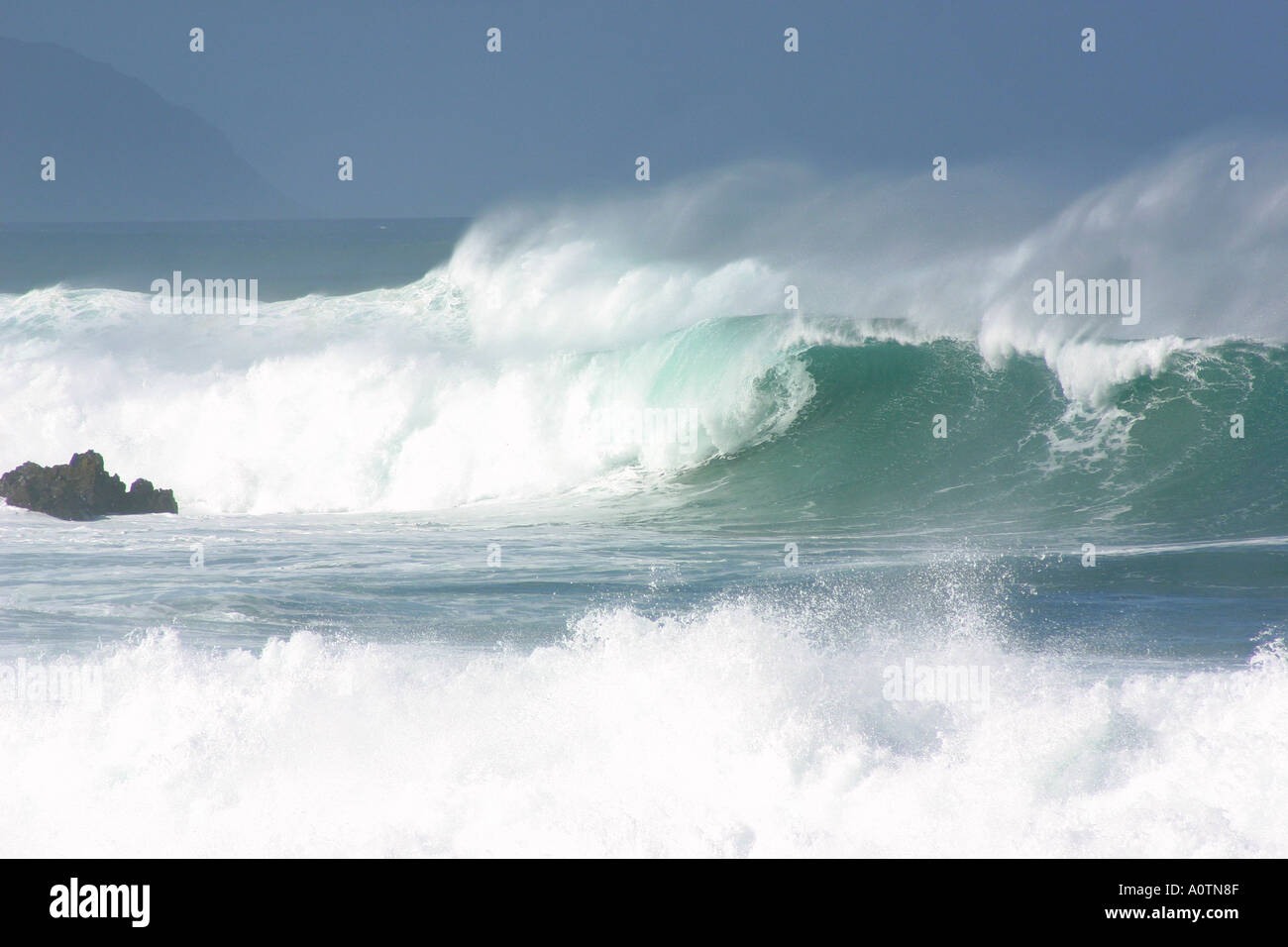 Massiccia ondata con windspray su roccia Waimea Bay North Shore di Oahu Hawaii Foto Stock