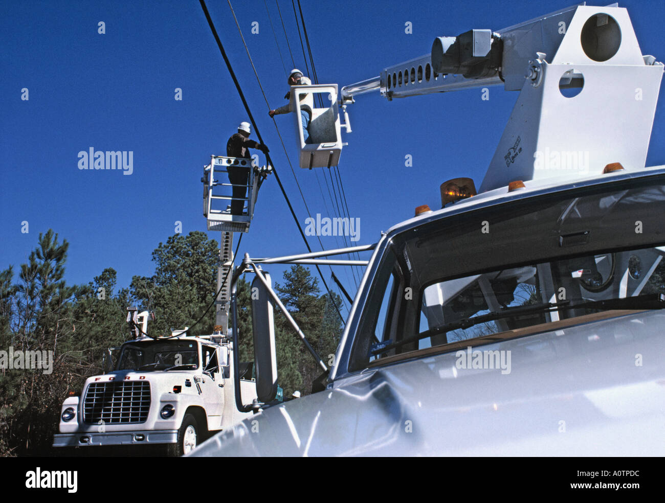 Telefono guardafili di installare il nuovo cavo utilizzando un carrello della benna o cherry picker Foto Stock
