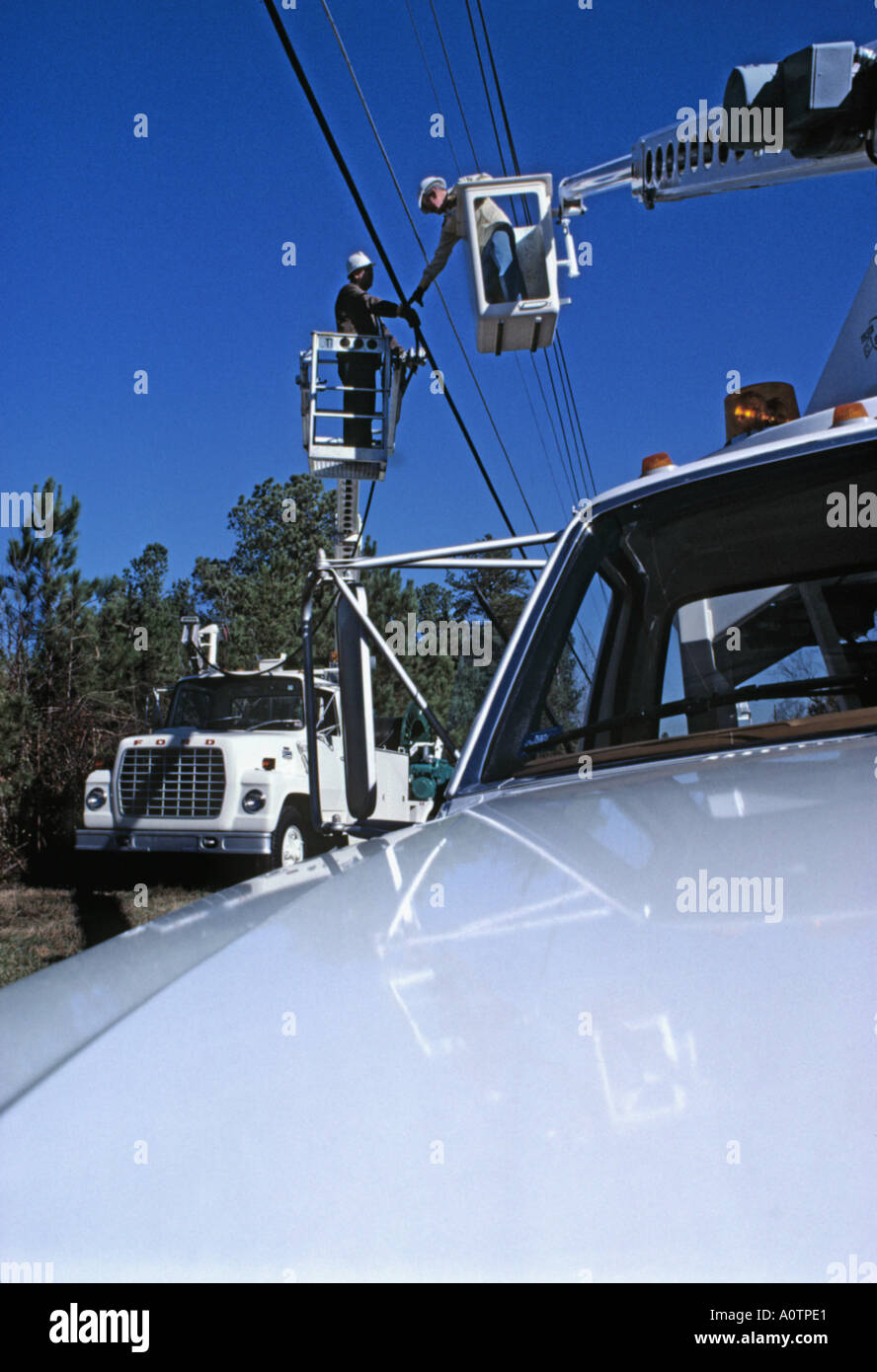 Telefono guardafili di installare il nuovo cavo utilizzando un carrello della benna o cherry picker Foto Stock