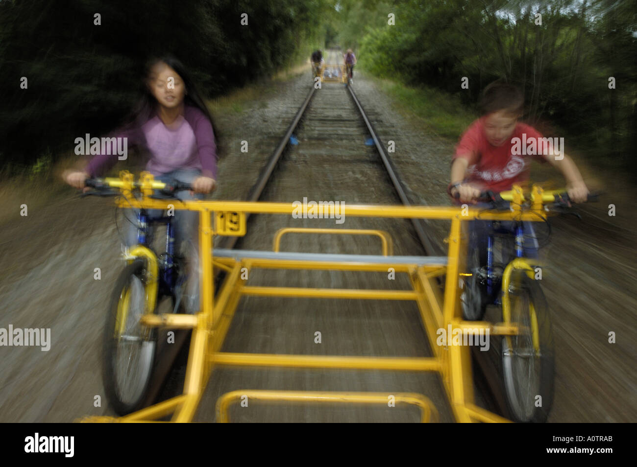 Due bambini in sella a una moto speciale su un binario ferroviario Foto Stock