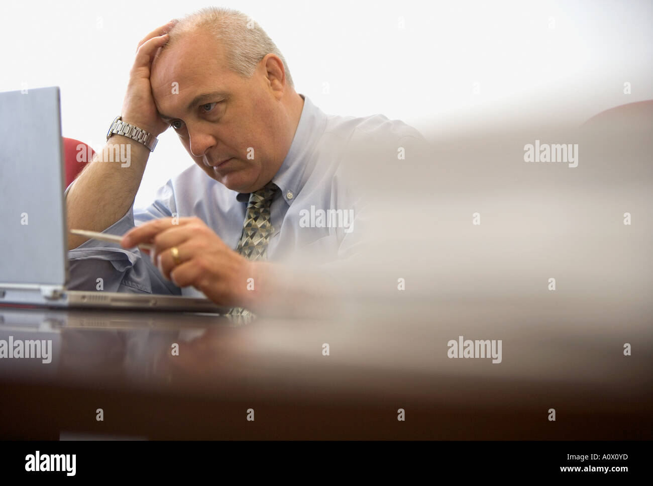 Sottolineato business executive lavorando sul computer portatile in ufficio sala conferenza Foto Stock