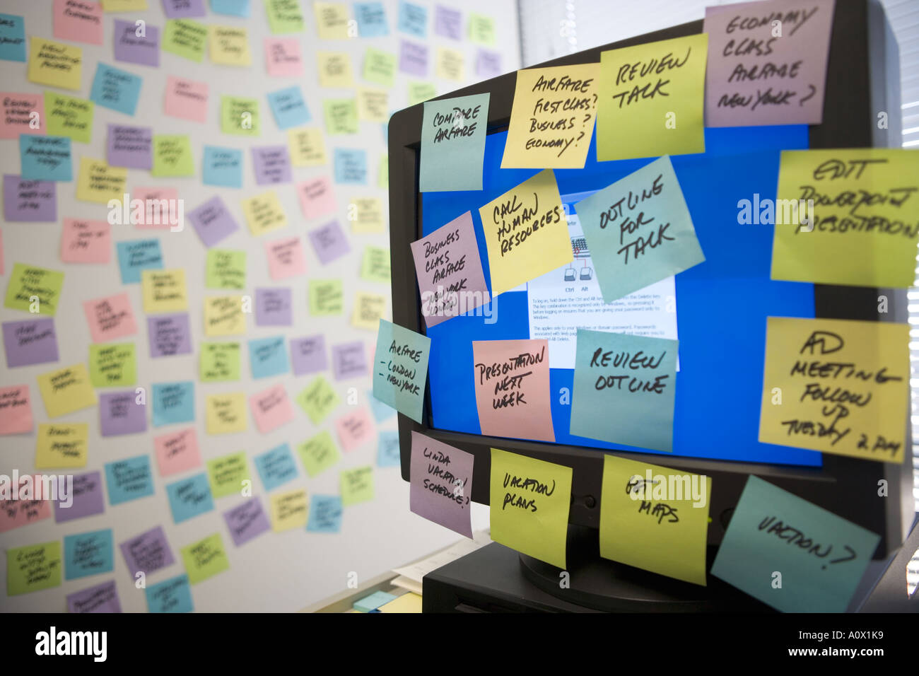 Sticky Notes riempire il monitor del computer e la parete per ufficio Foto Stock