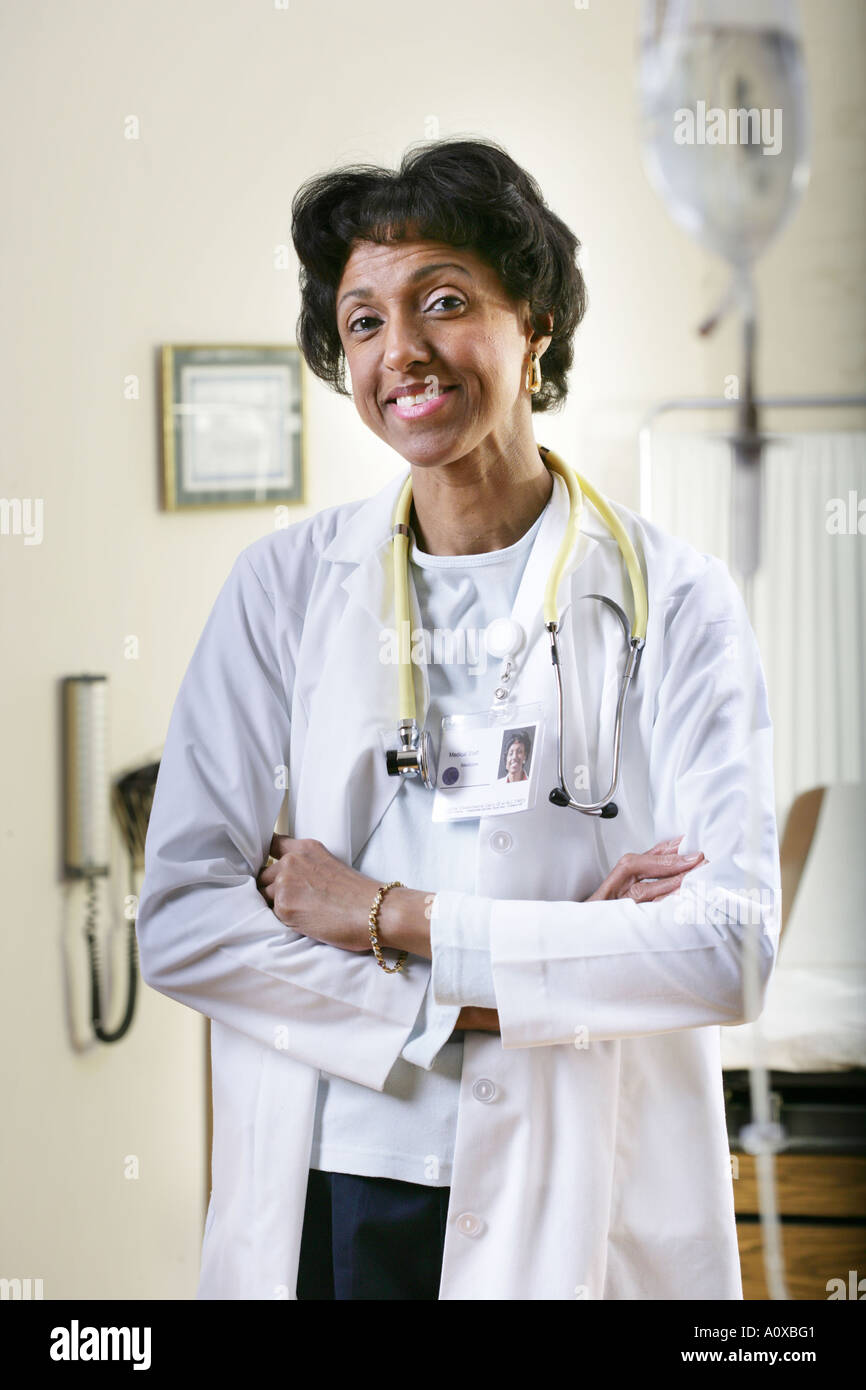 Avanti. Medico donna nella sua sala esame, sorride. Foto Stock