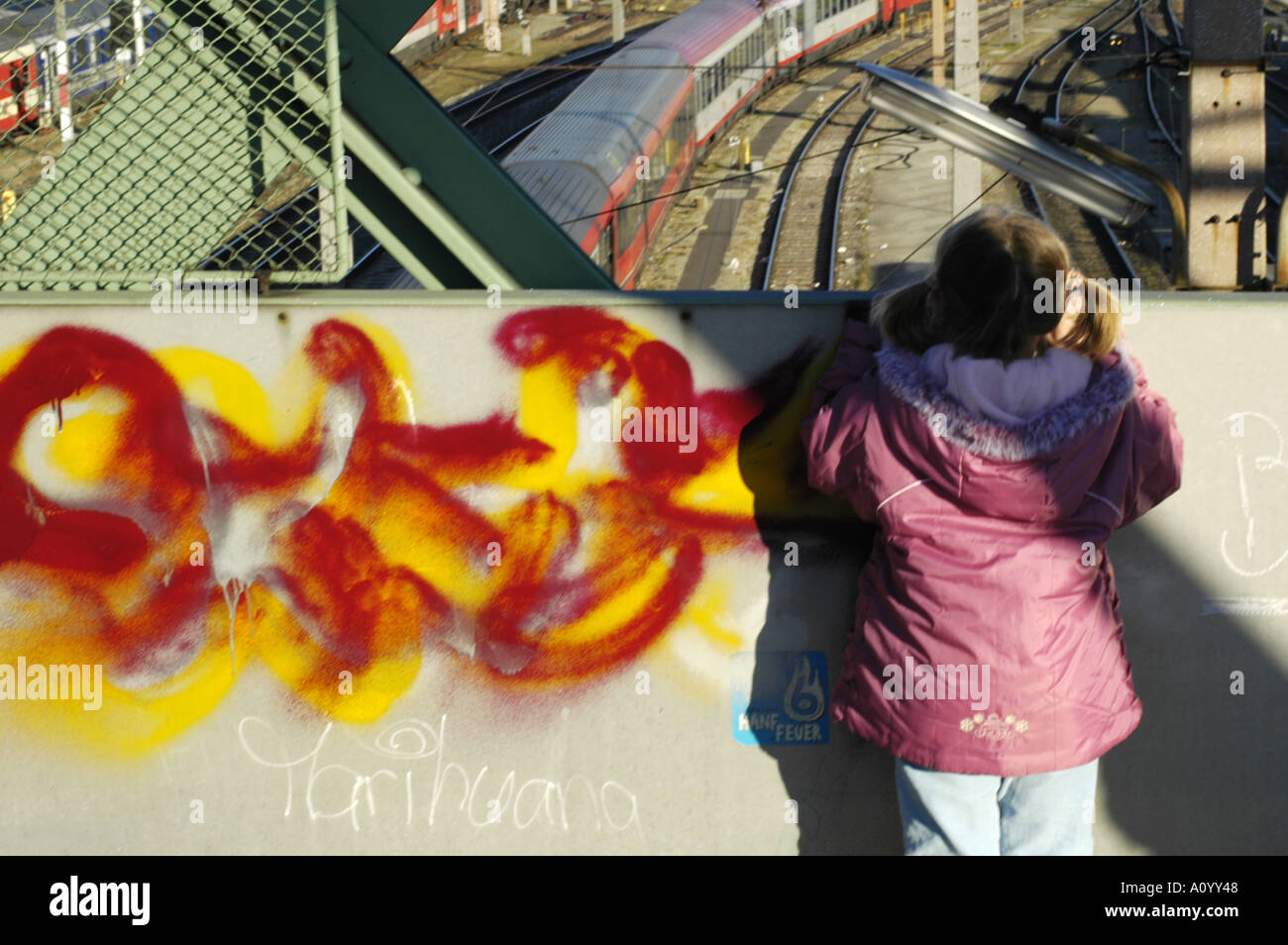 Ragazza giovane di fronte ad una parete grafitti Foto Stock