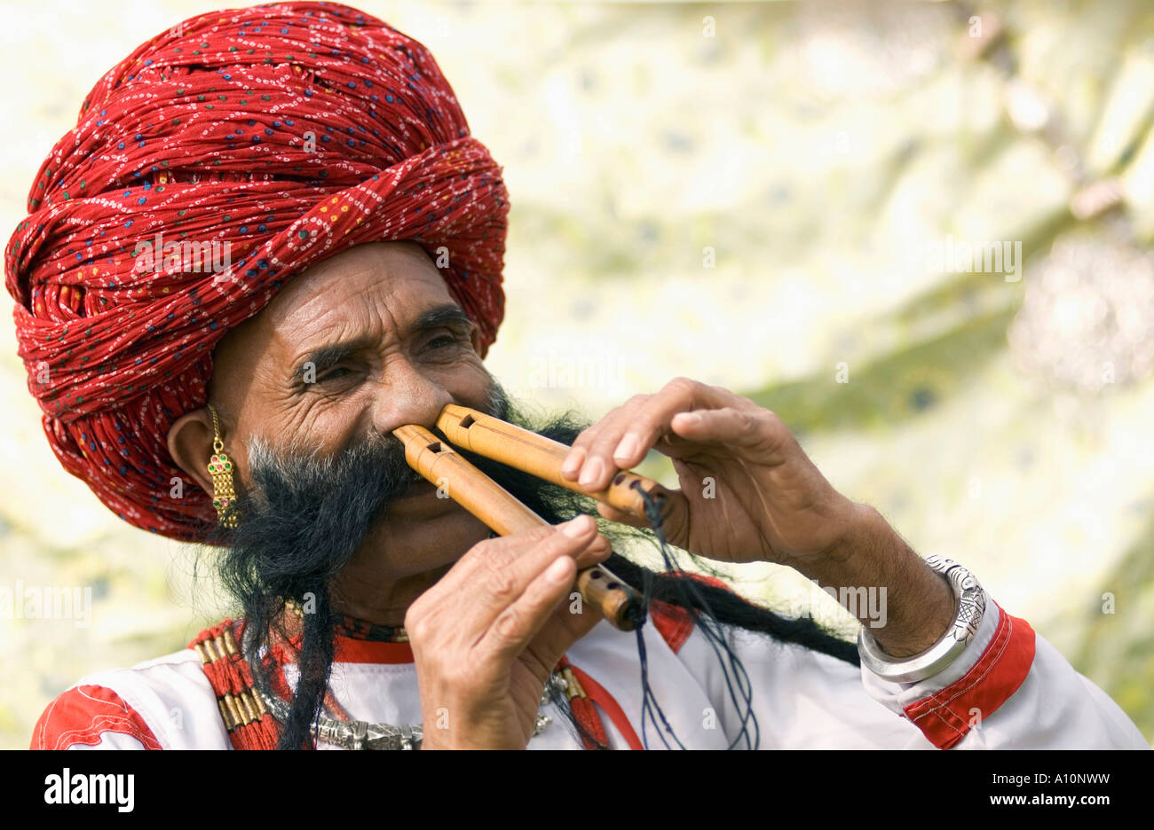 Close-up di un uomo maturo la riproduzione di due scanalature con il suo naso, Jaipur, Rajasthan, India Foto Stock