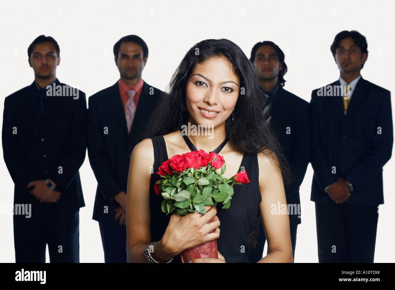 Ritratto di una giovane donna tenendo un bouquet di fiori con quattro uomini di affari in piedi dietro di lei Foto Stock