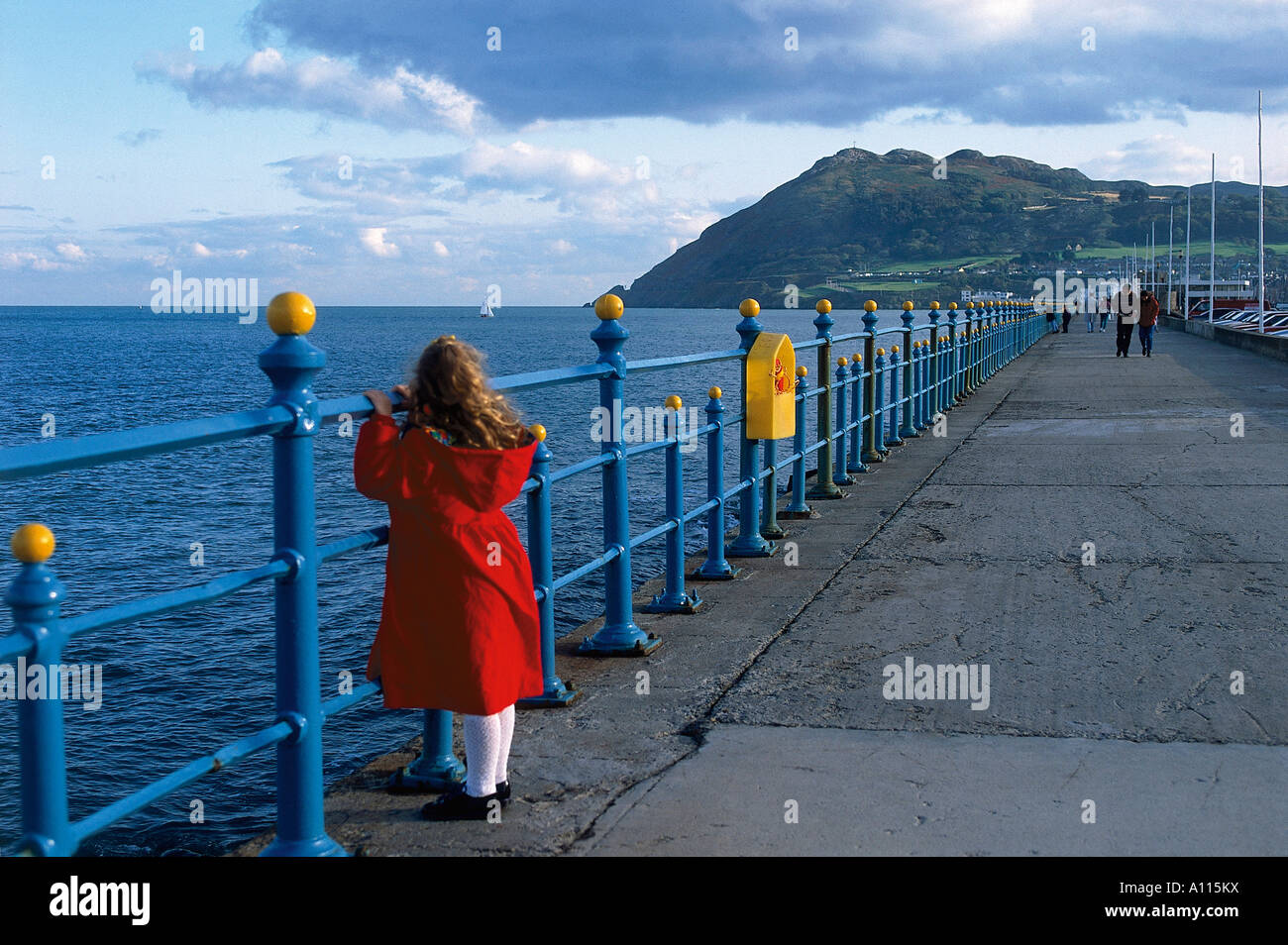 Ragazza appoggiata contro le ringhiere sulla lunga passeggiata guardando verso il ripido pendio di Bray Head Foto Stock