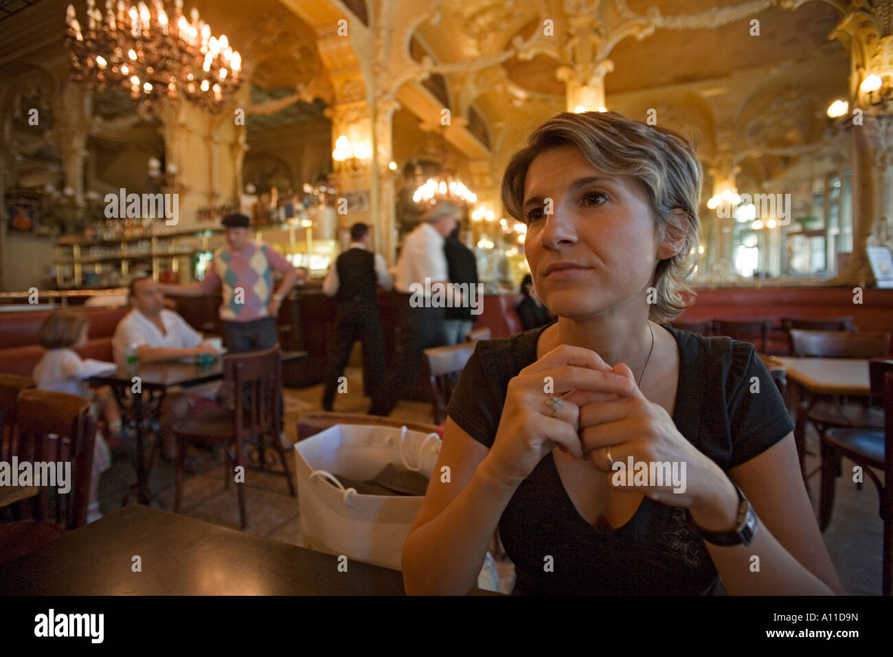 Una giovane donna single in attesa 'Grand Cafe' di Moulins. Jeune femme patientant dans le 'Grand Café de Moulins (Francia). Foto Stock