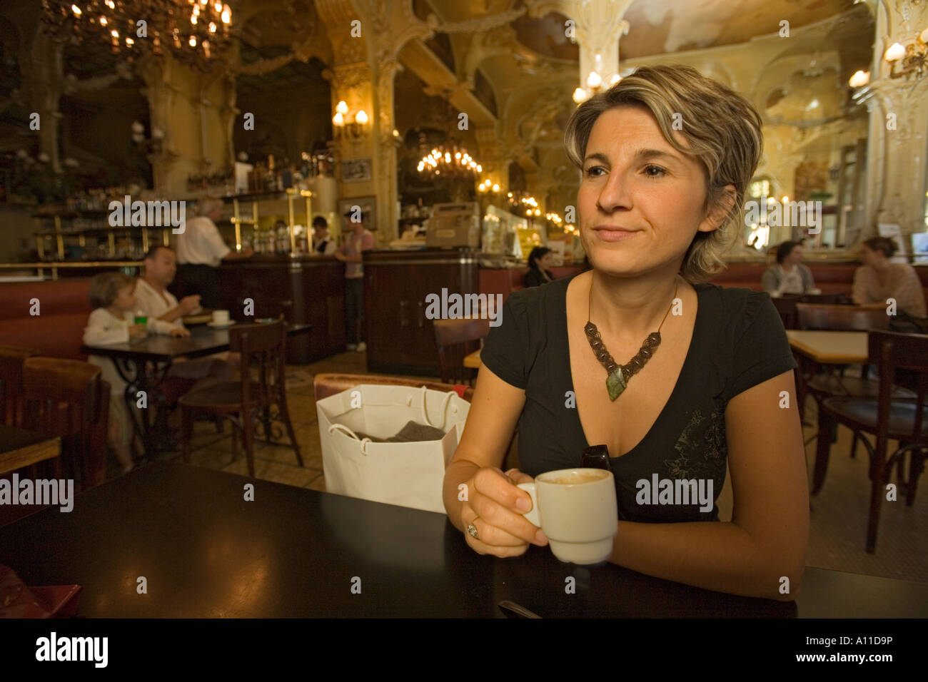 Una giovane donna single in attesa 'Grand Cafe' di Moulins. Jeune femme patientant dans le 'Grand Café de Moulins (Francia). Foto Stock