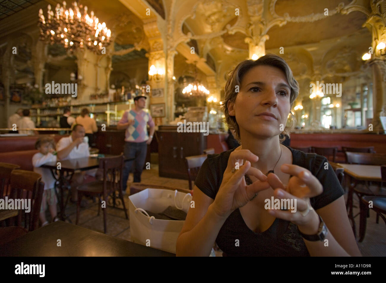 Una giovane donna single in attesa 'Grand Cafe' di Moulins. Jeune femme patientant dans le 'Grand Café de Moulins (Francia). Foto Stock