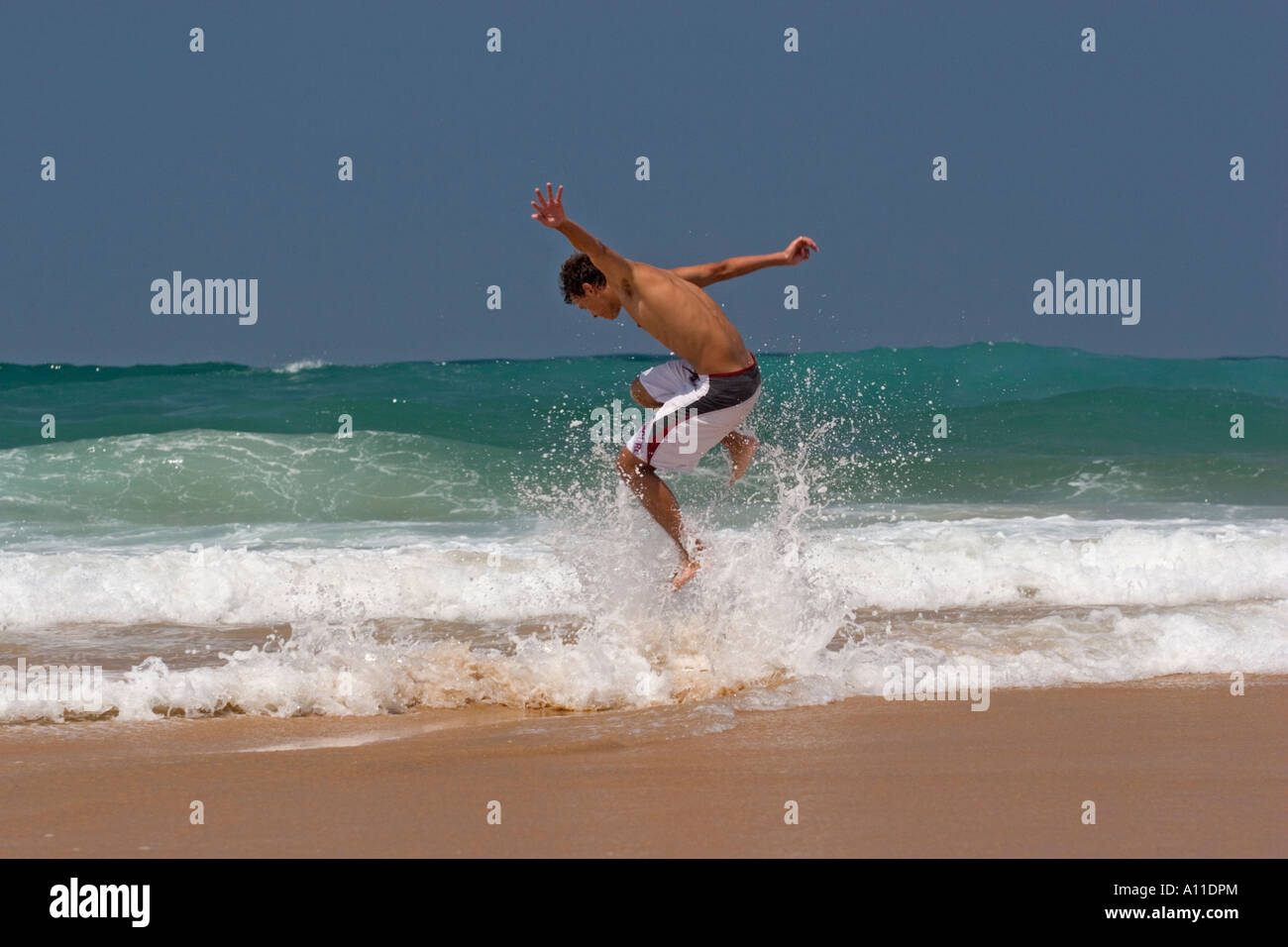 Un skimboarder sulla spiaggia Cordoama, in Algarve (Portogallo). Skimboarder sur la plage de Cordoama, en Algarve (Portogallo). Foto Stock