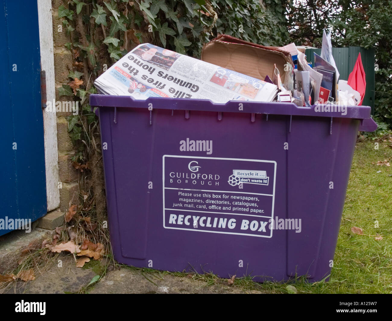 Riciclaggio viola scatola piena di rifiuti domestici di cartone carta si fermò al di fuori Foto Stock