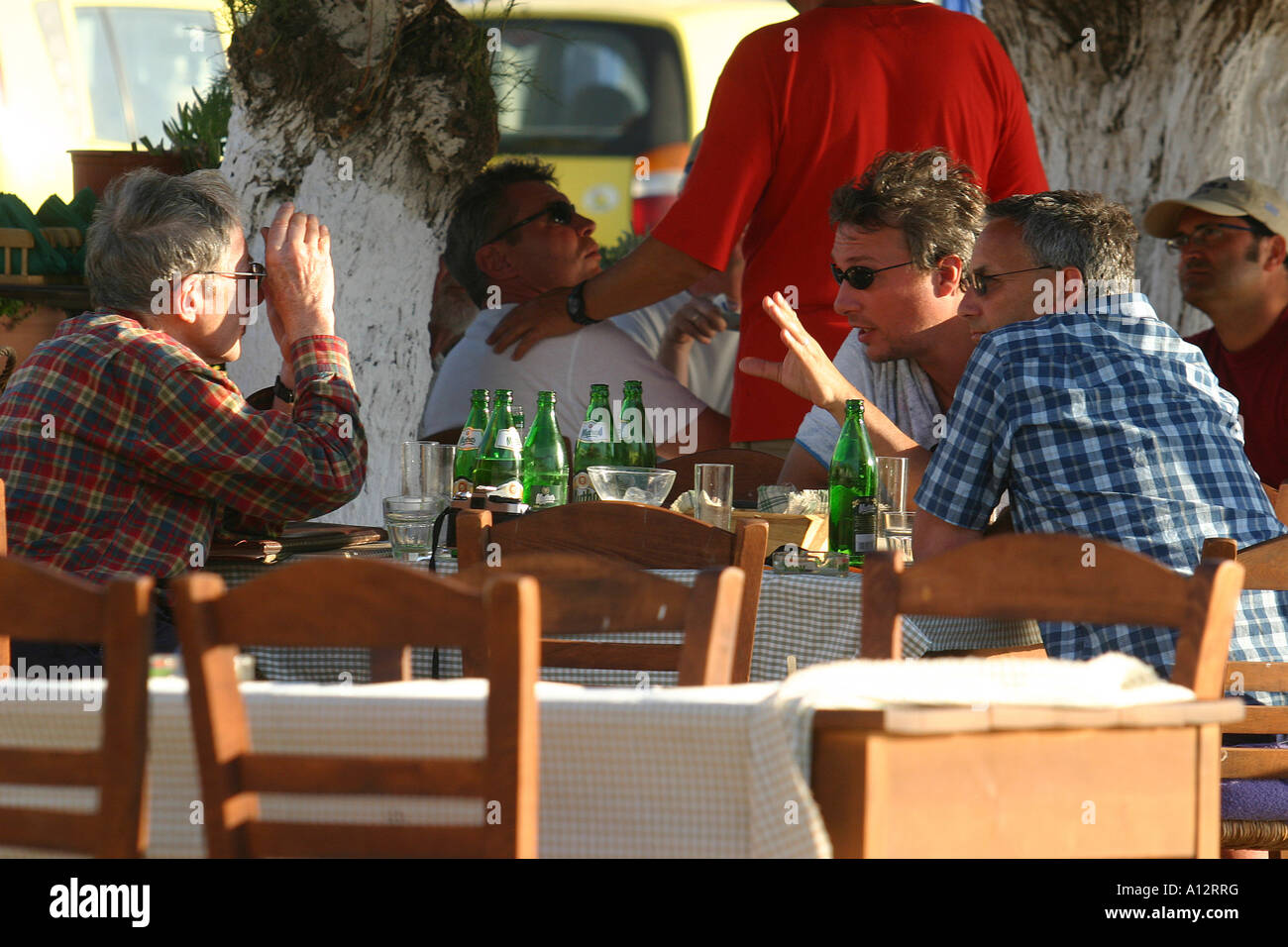 Gli uomini a discutere di soggetto sconosciuto su birra presso un ristorante tabella Foto Stock