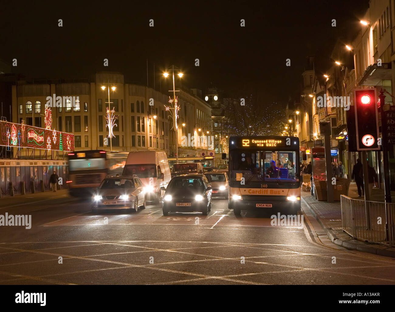 Il traffico e il trasporto pubblico bus nel centro della città di notte Cardiff Wales UK Foto Stock