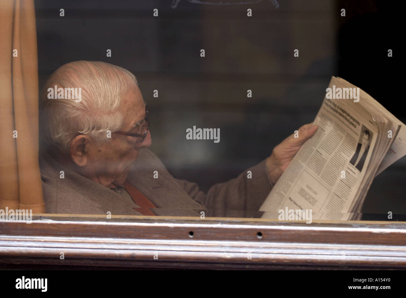 Anziano gentiluomo quotidiano di lettura in una caffetteria di spagnolo Foto Stock