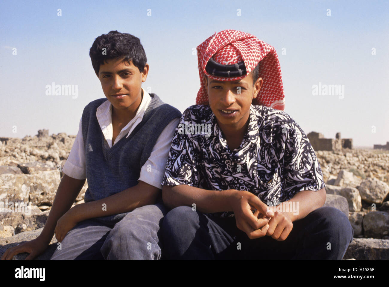 Ritratto di due giovani guide locali uno indossando il tradizionale headcloth presso le rovine di Umm al Jimal Giordania Medio Oriente K Gillham Foto Stock