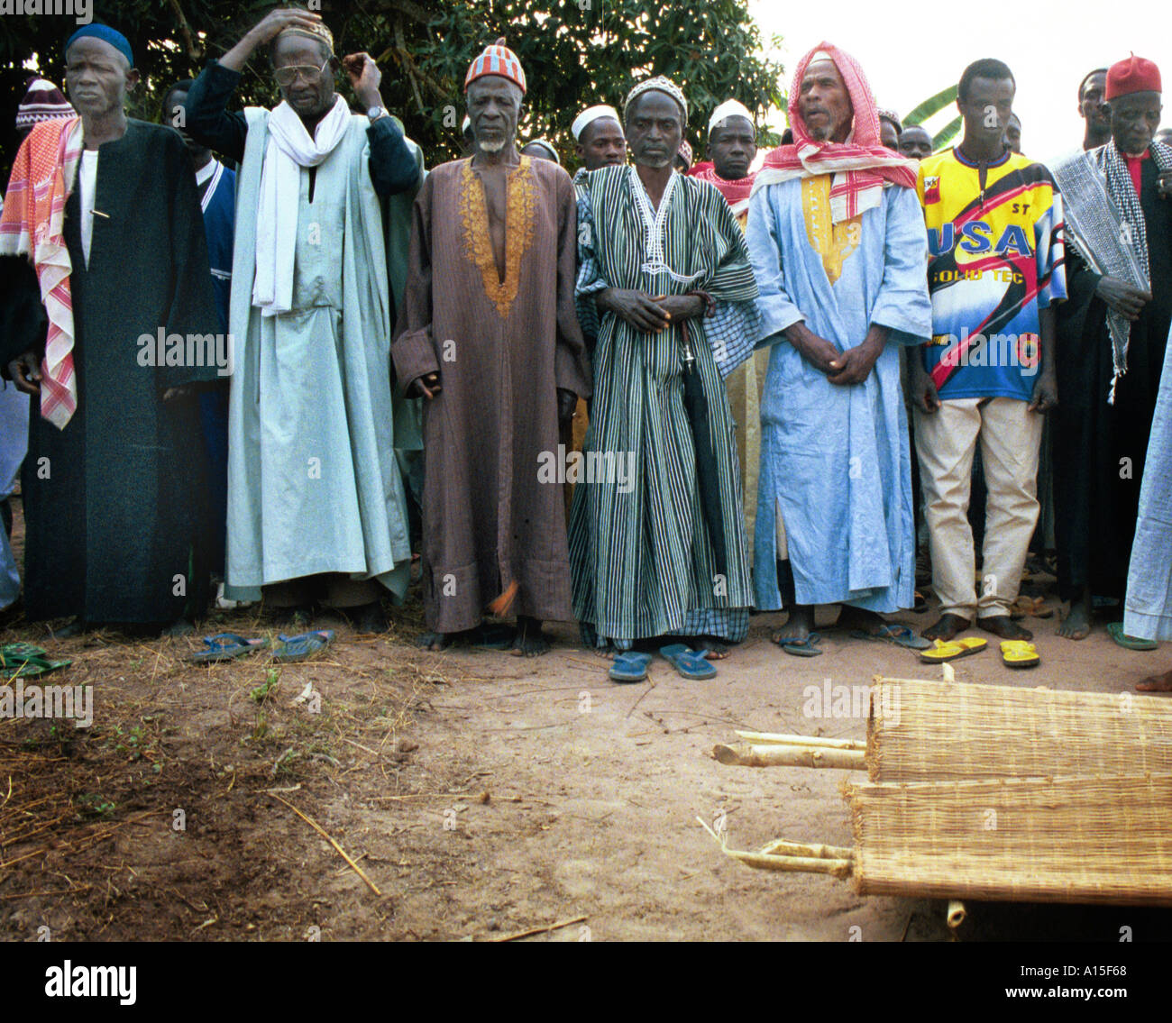 Gli anziani del villaggio di pagare i loro aspetti a un funerale di una giovane madre che muore di una malattia sconosciuta probabilmente la malaria in il musulmano Foto Stock