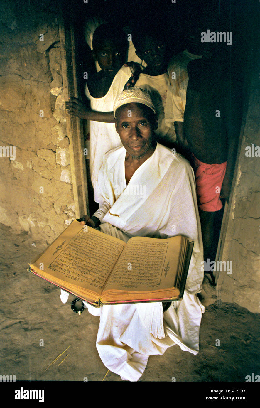 Mamadou Lama l'insegnante religiosa nel villaggio di Dembel Jumpora legge il Corano dentro la sua casa di fango nella regione orientale Foto Stock