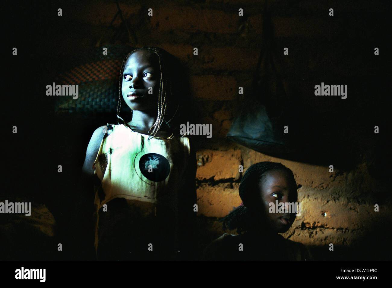 Le ragazze del villaggio di Dembel Jumpora nel paese africano e Dell'ovest della Guinea Bissau sedersi dentro il loro tetto di paglia rifugio a Foto Stock