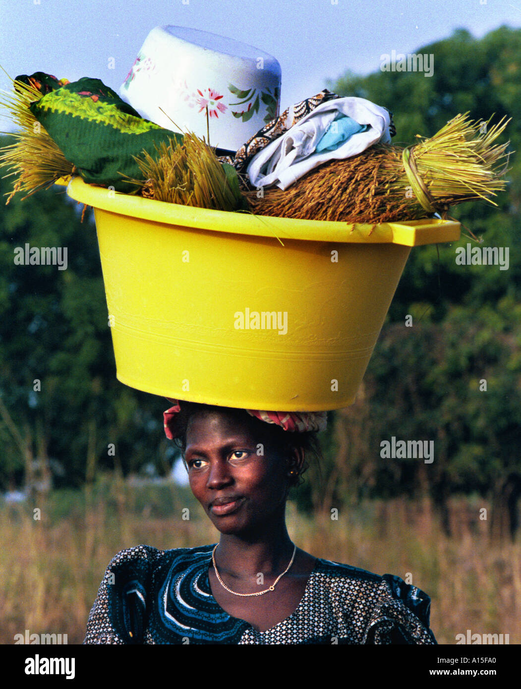 Una donna dal villaggio di Dembel Jumpora nel paese africano e Dell'ovest della Guinea Bissau torna dai campi dopo Foto Stock
