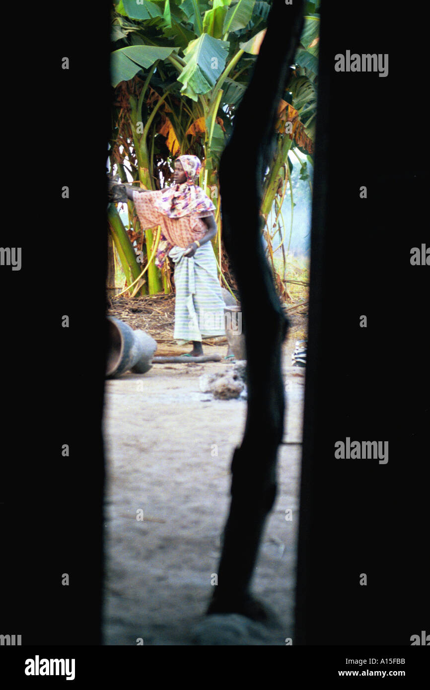 Uma lama è mostrata attraverso la fessura di una porta e lei inizia la routine di giorni nel villaggio di Dembel Jumpora in Occidente Foto Stock