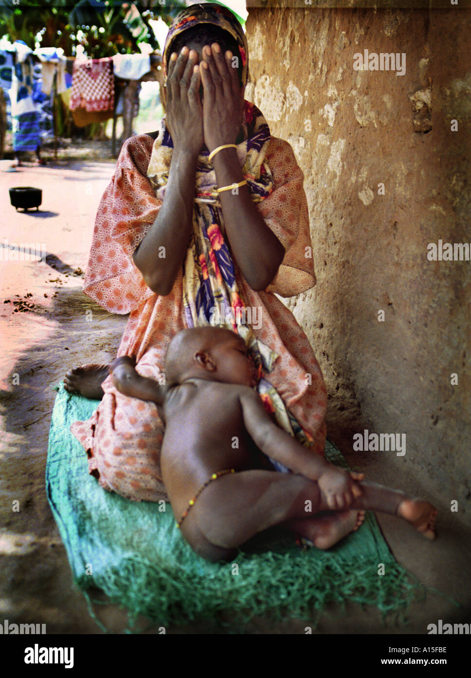 Lama Uma rende le preghiere del pomeriggio come il suo bambino dorme sul suo giro nel paese africano e Dell'ovest della Guinea Bissau. Le donne in questo Foto Stock